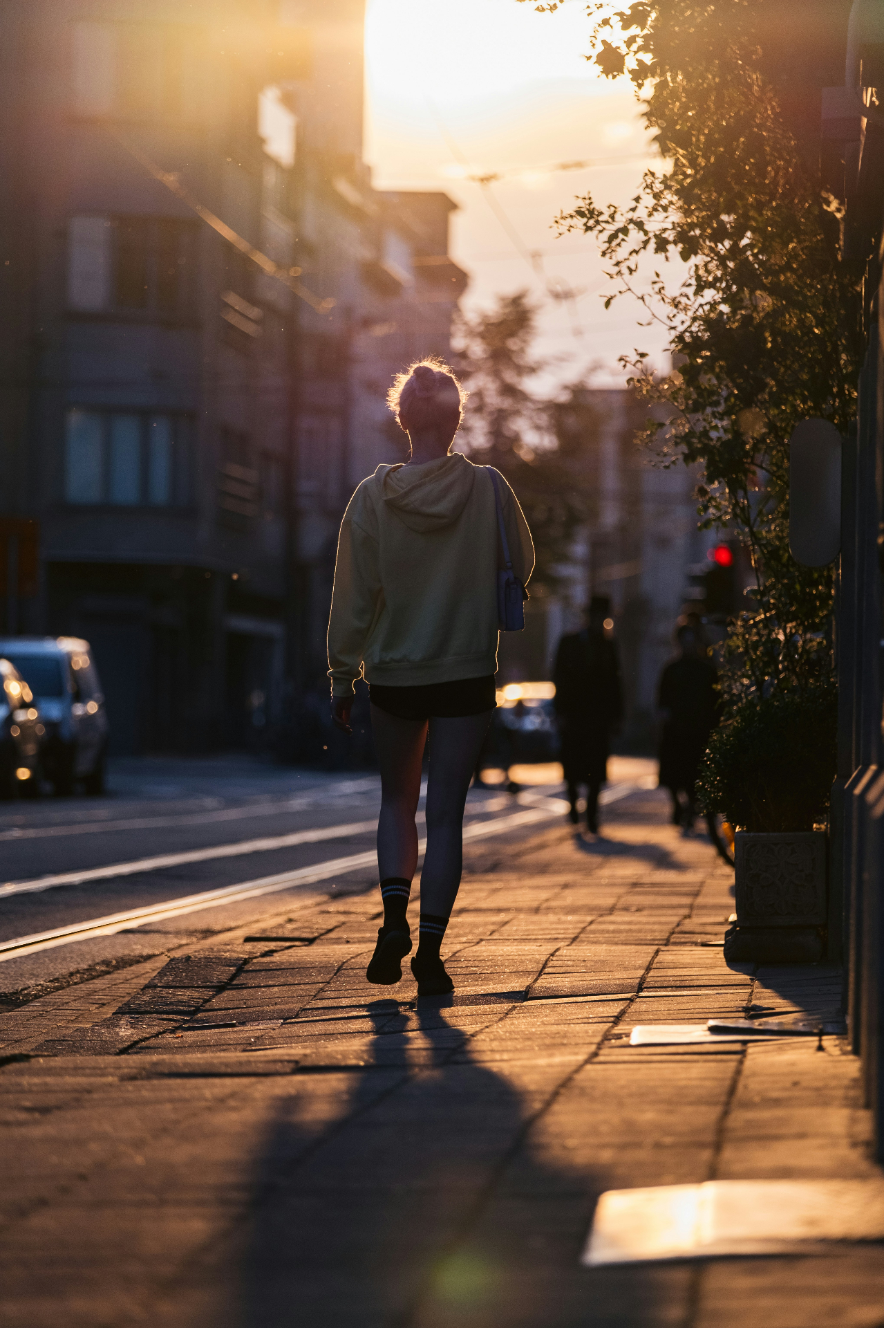 Woman walking down a city street at golden hour